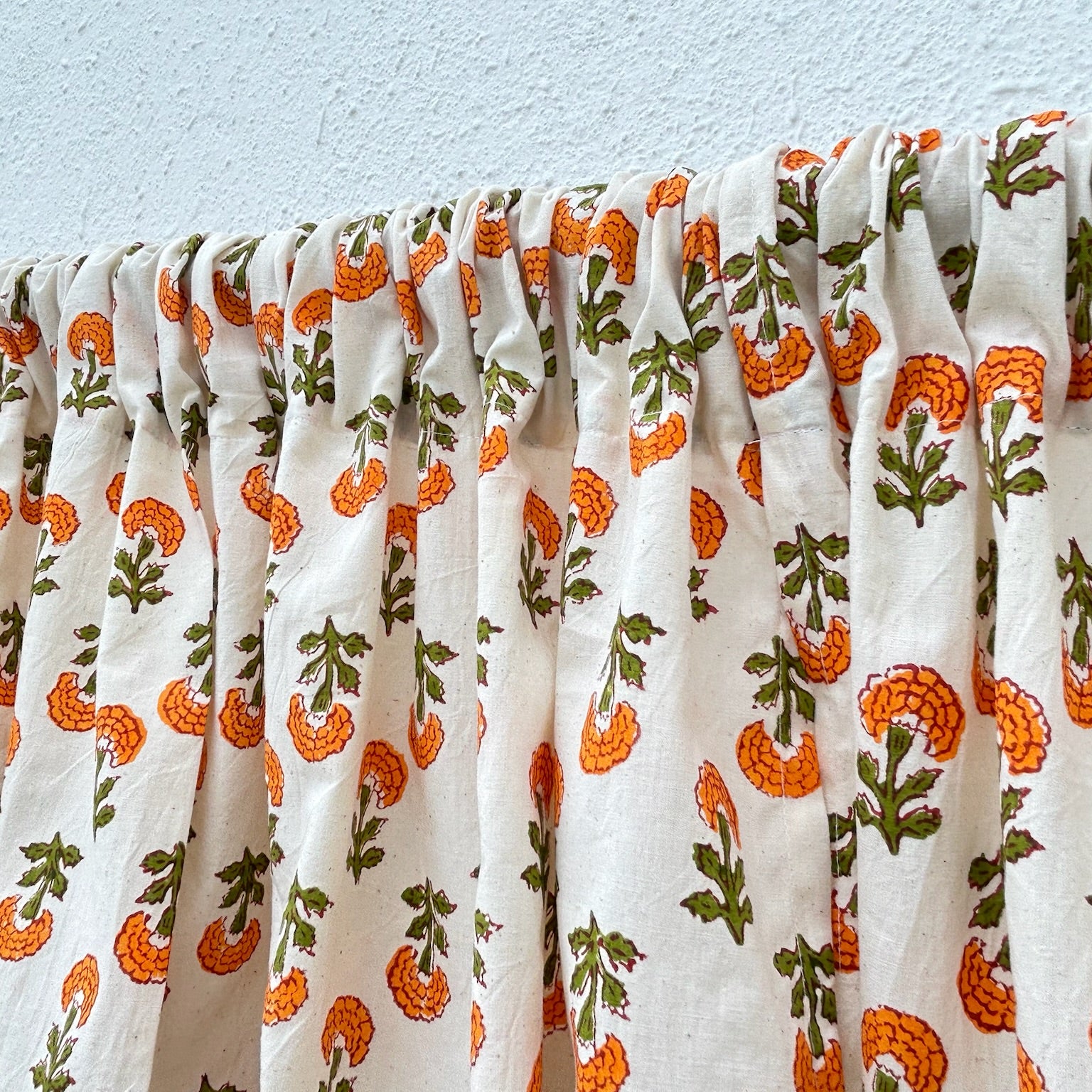 Floral patterned fabric with orange and green flowers on a white background