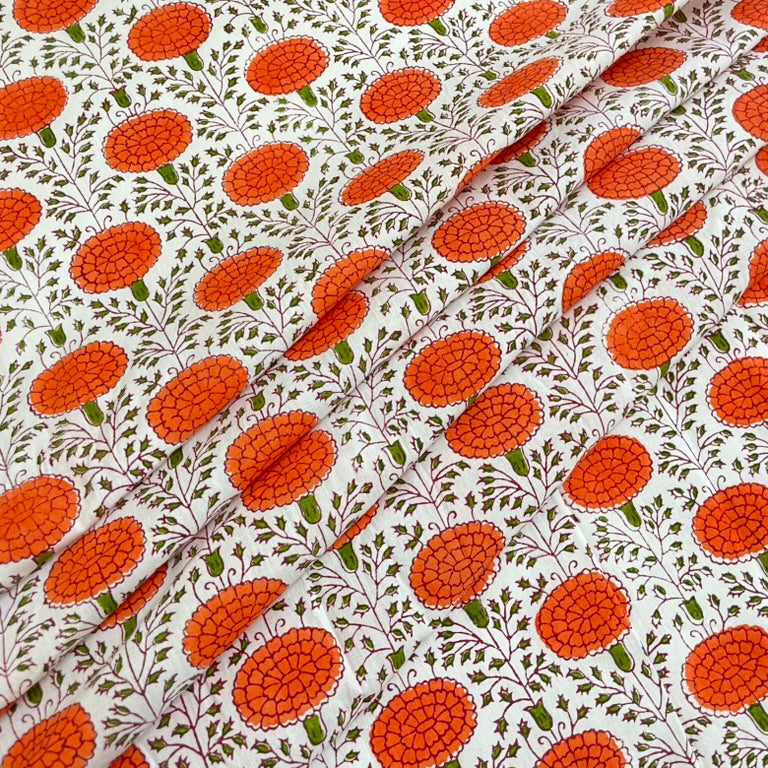 Fabric with orange floral pattern on a white background