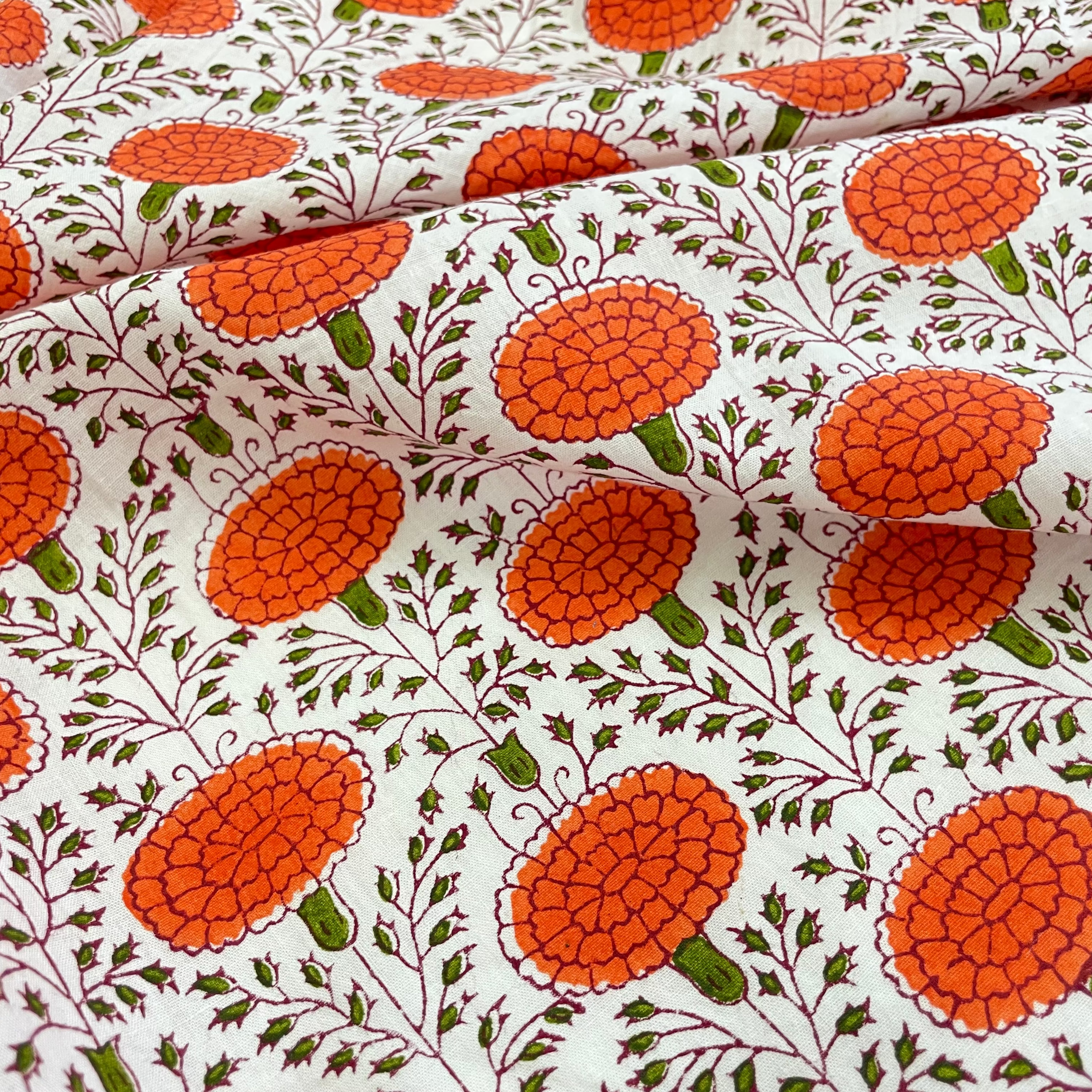 Fabric with orange floral pattern on a white background
