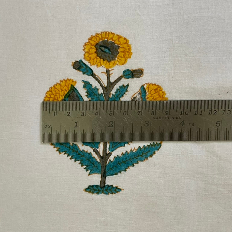 Embroidered floral design with a ruler for scale on a light background