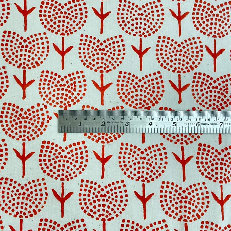 Fabric with orange tulips pattern and a ruler for scale on a light background