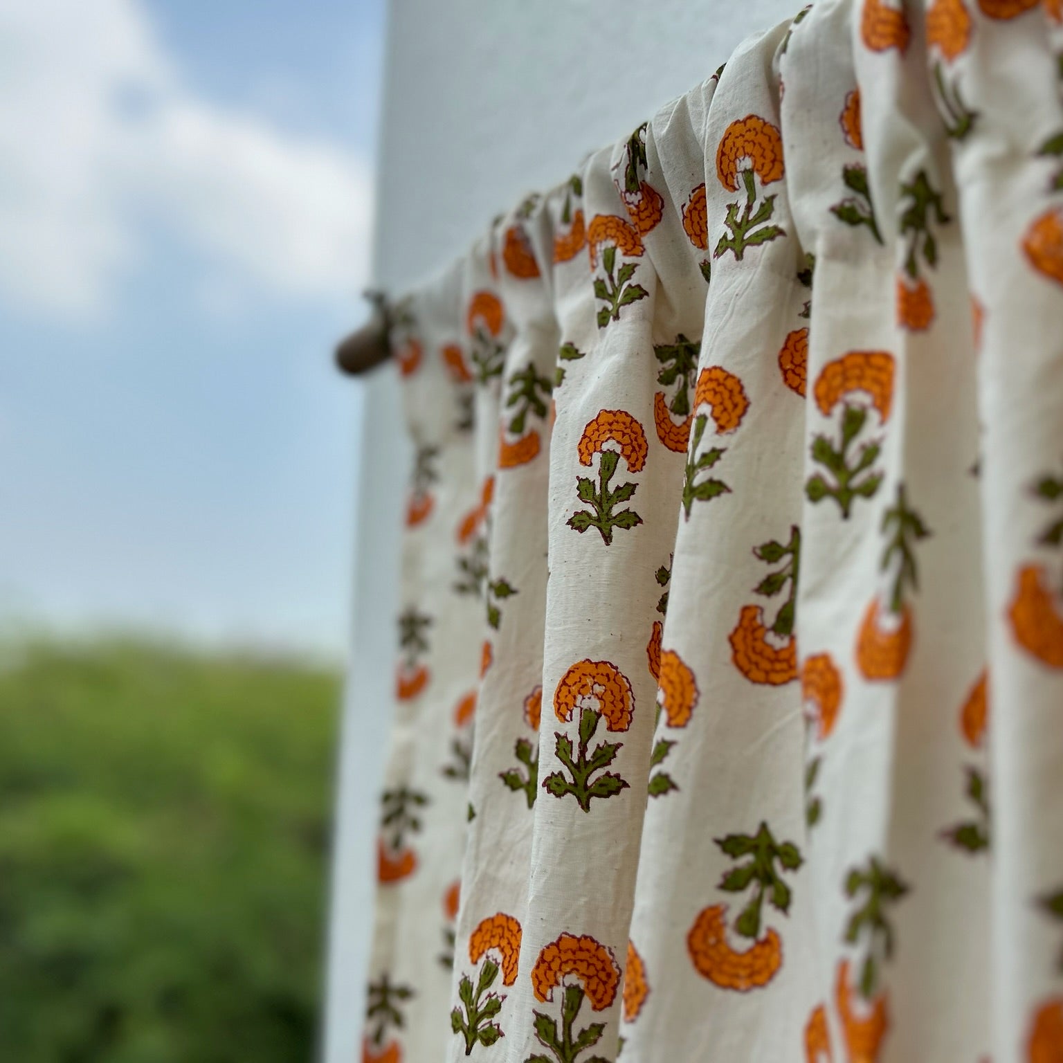 Floral-patterned fabric hanging outdoors with a blurred natural background