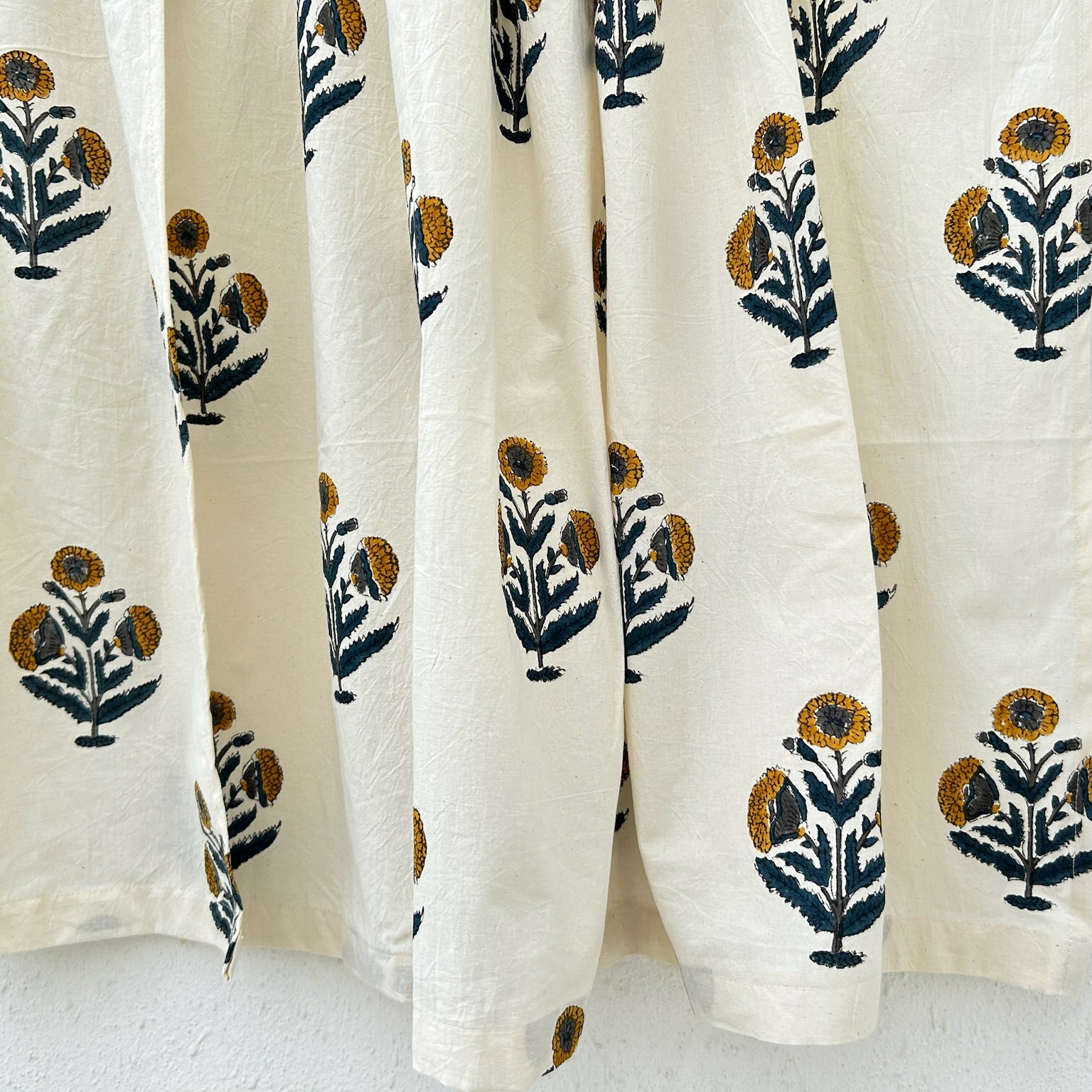 White curtains with black and gold floral patterns on a white background