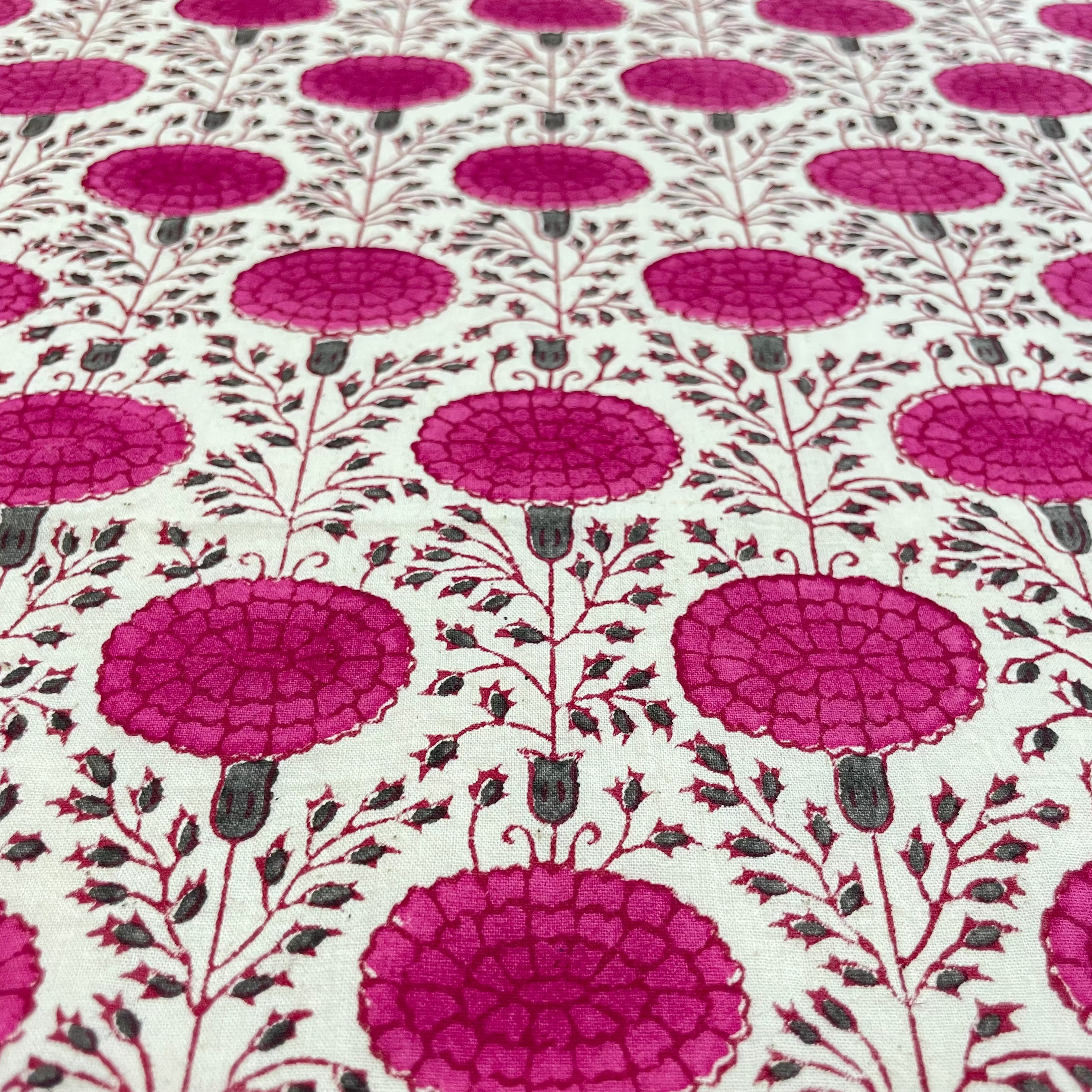 Fabric with a pattern of pink floral designs on a white background