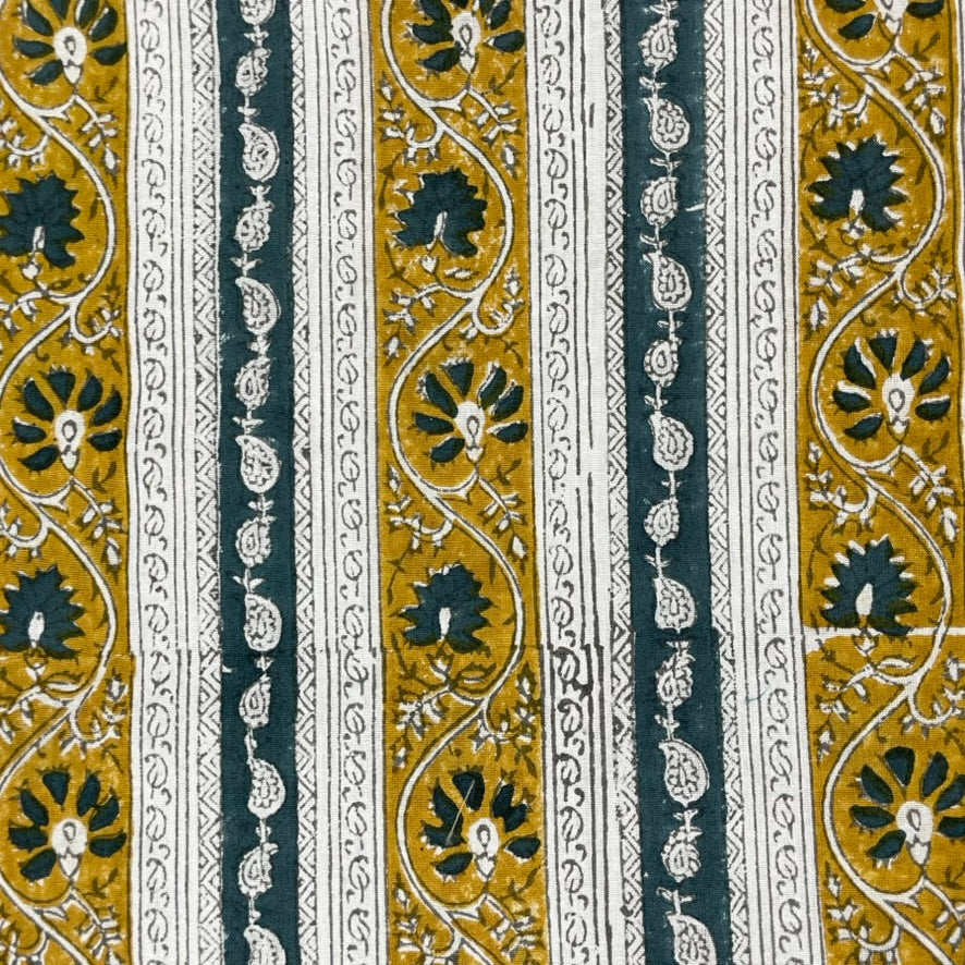 Patterned fabric with black, gold, and white design on a striped background