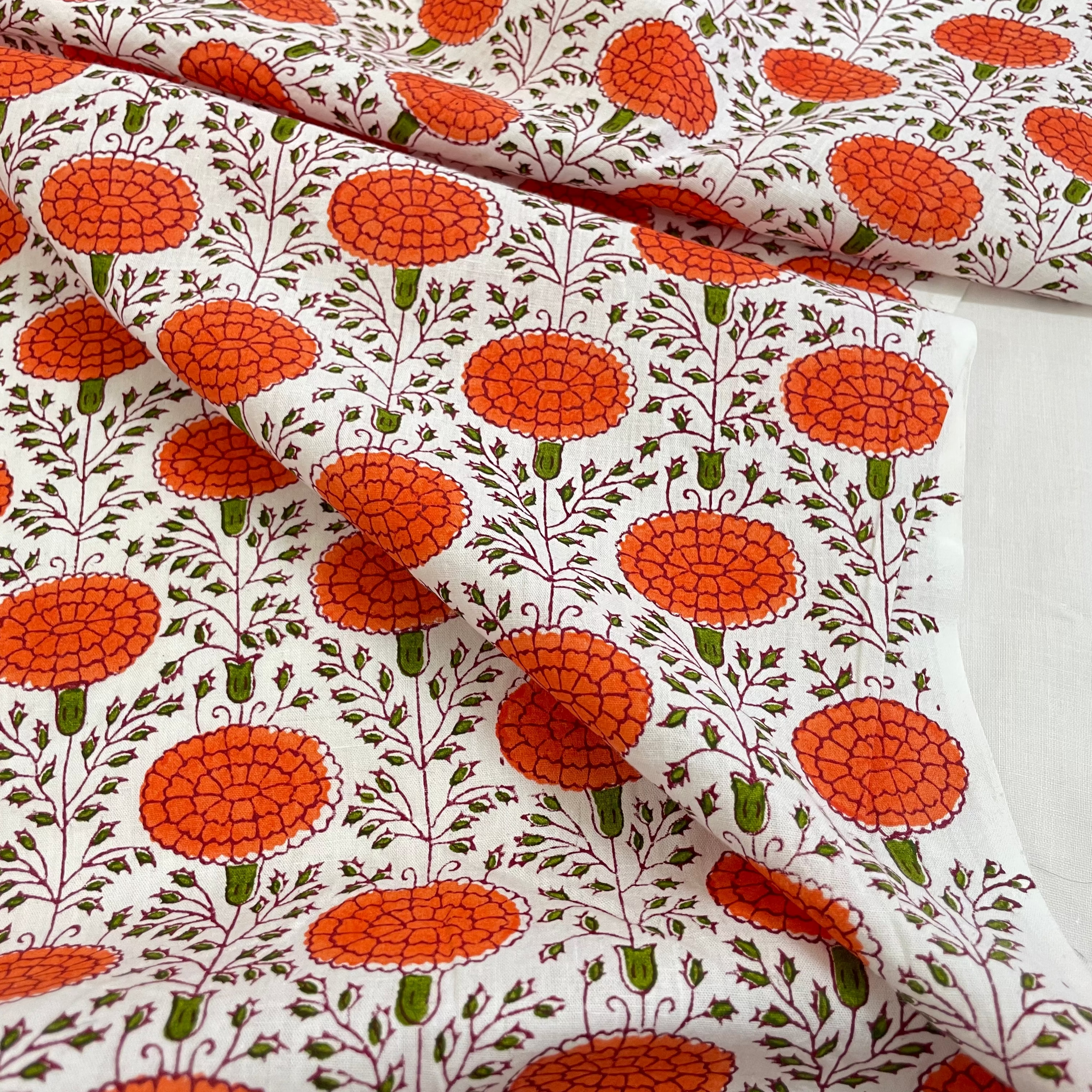 Floral patterned fabric with orange flowers on a white background