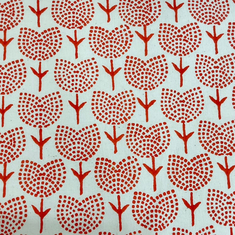 Patterned fabric with red tree-like shapes on a beige background