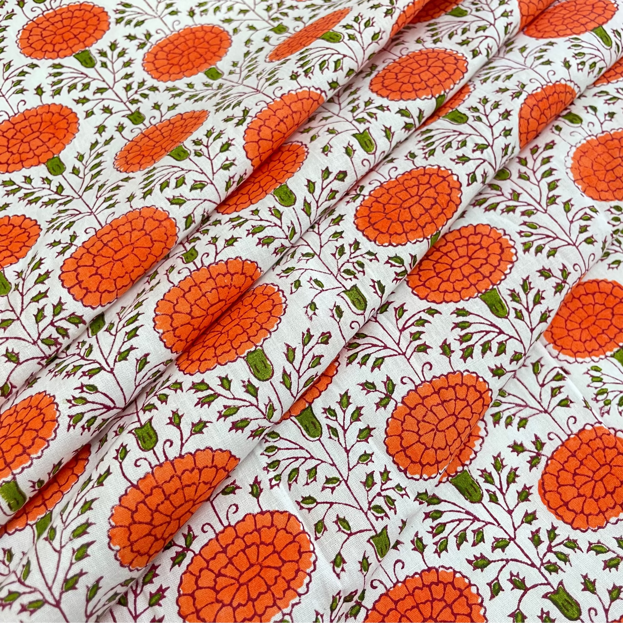 Fabric with orange floral pattern on a white background