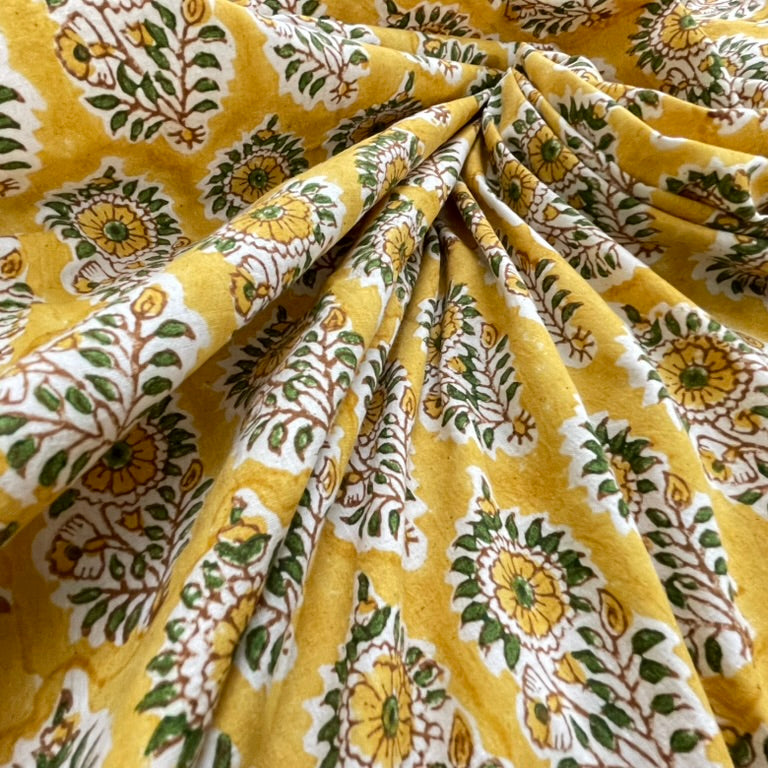 Yellow fabric with green and white floral patterns