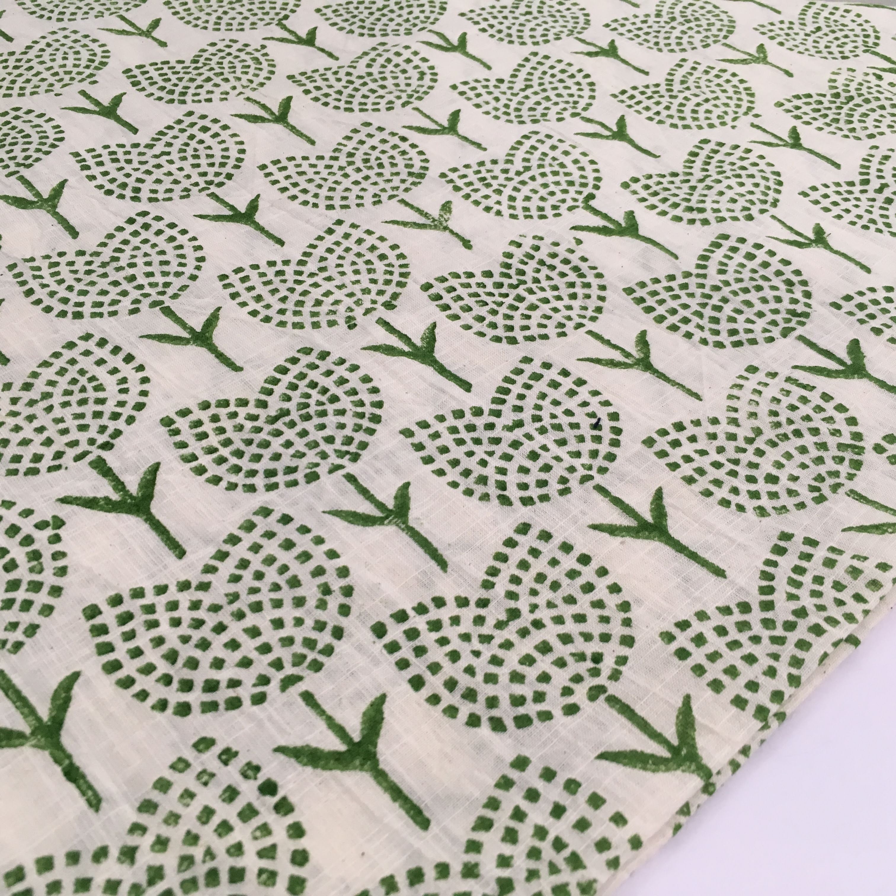 Green floral pattern on a white fabric background