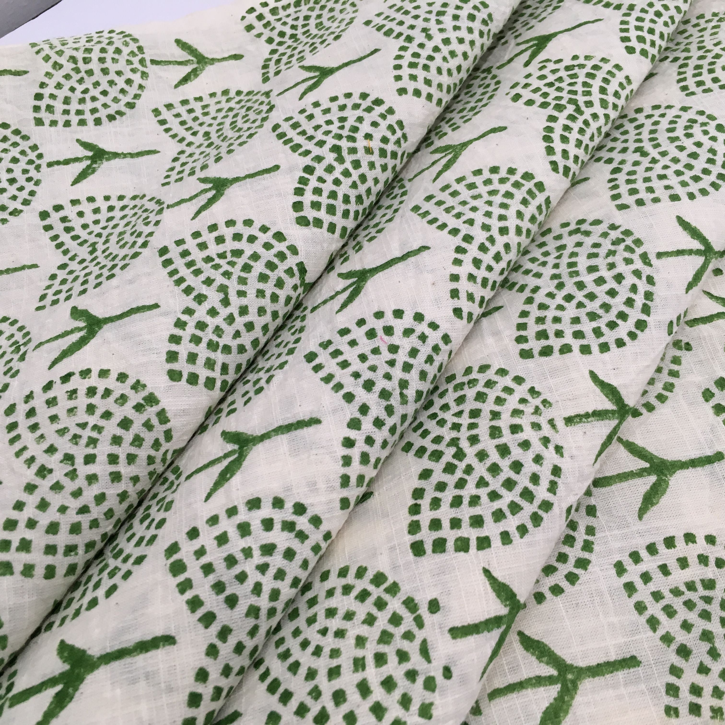Fabric with green geometric pattern on a beige background