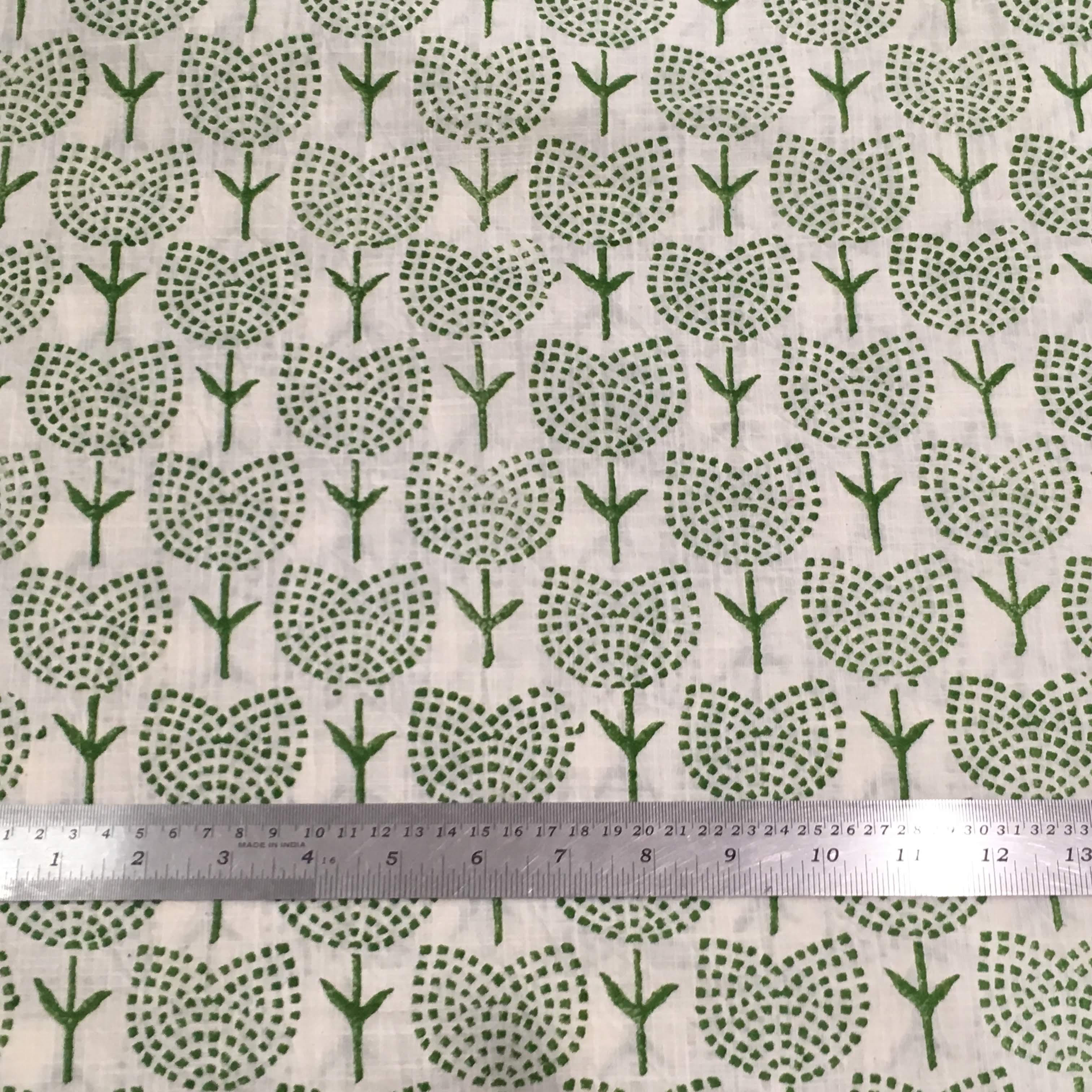 Green tree pattern on beige fabric with a ruler for scale