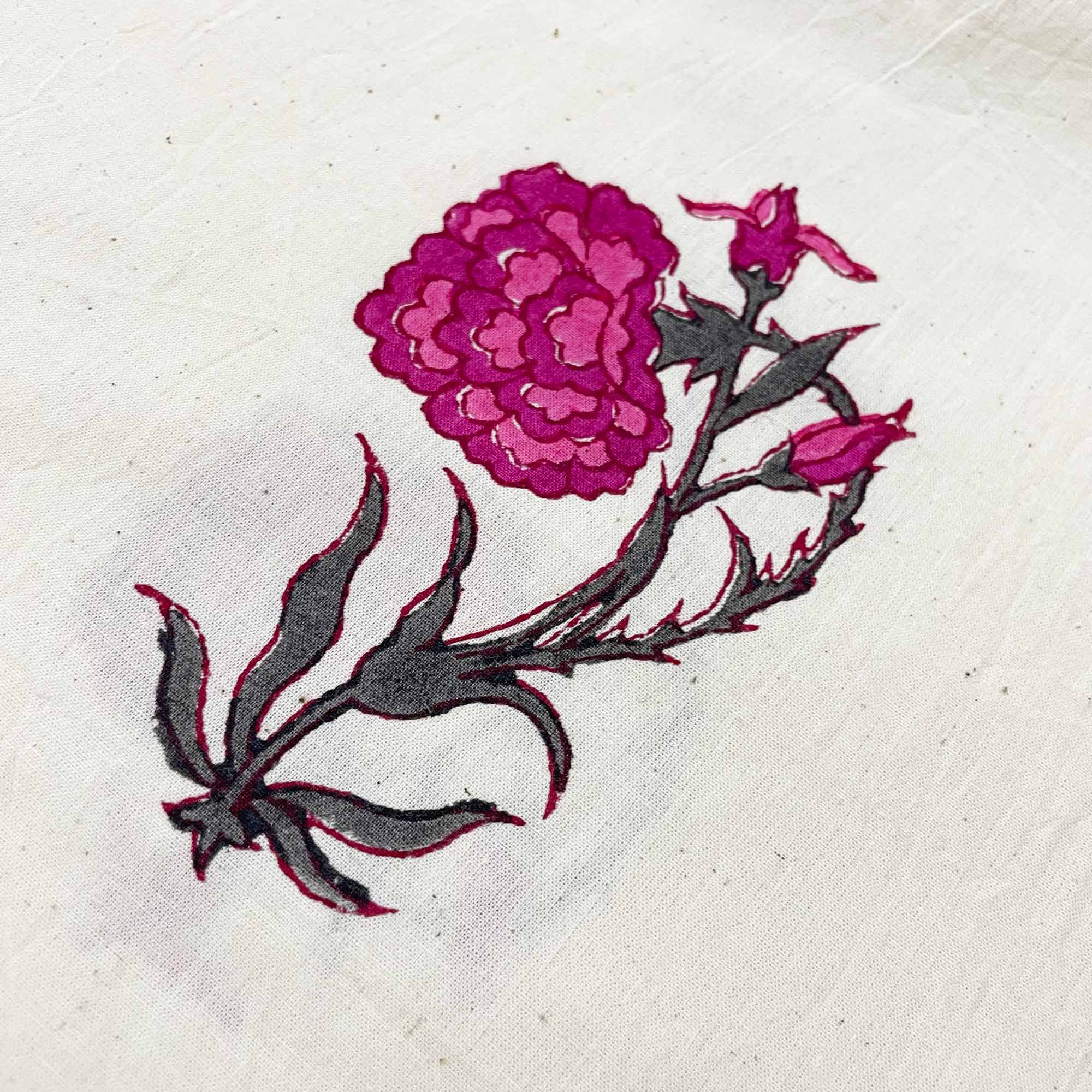 Embroidered design of a pink flower on a white fabric background