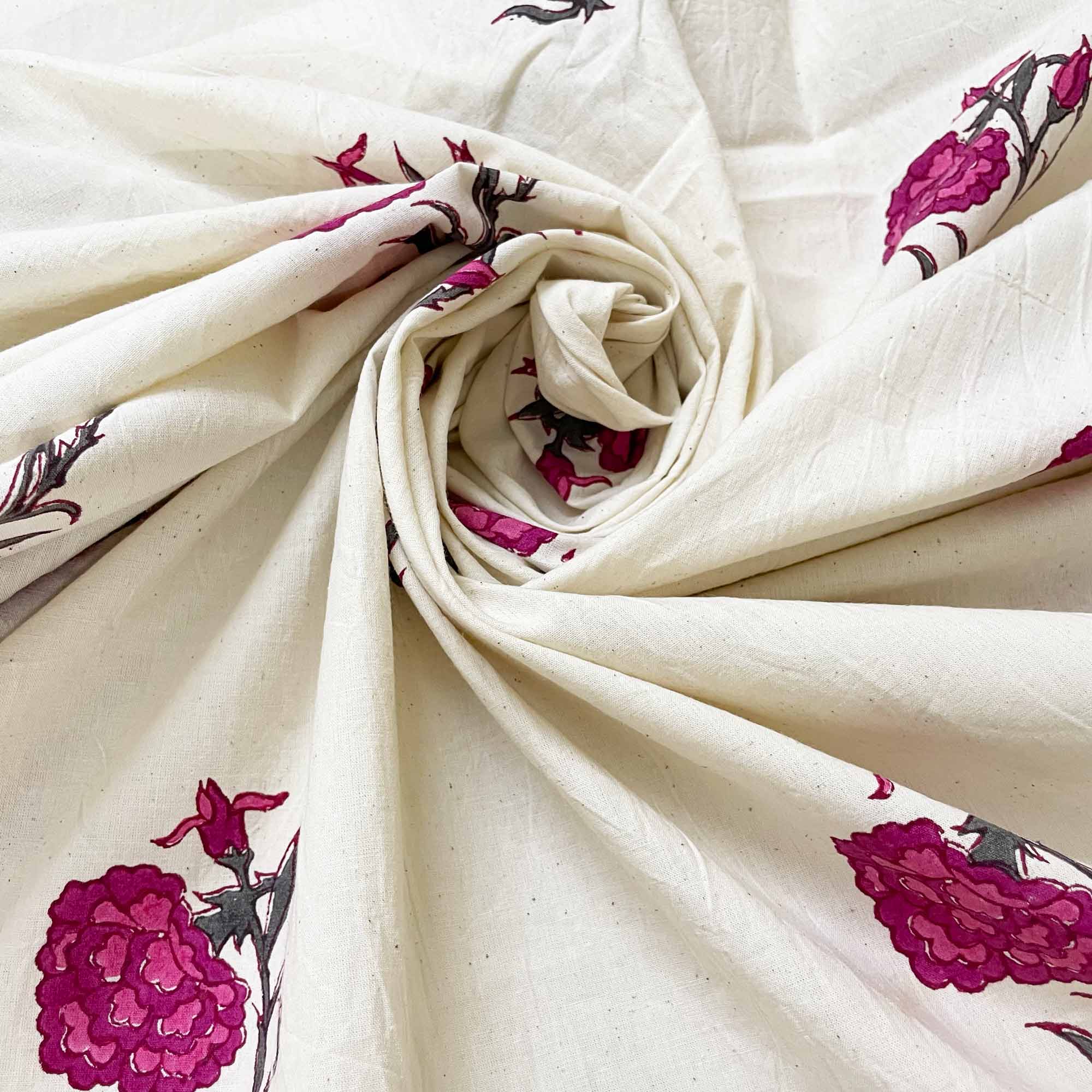 Rolled-up fabric with pink floral patterns on a white background