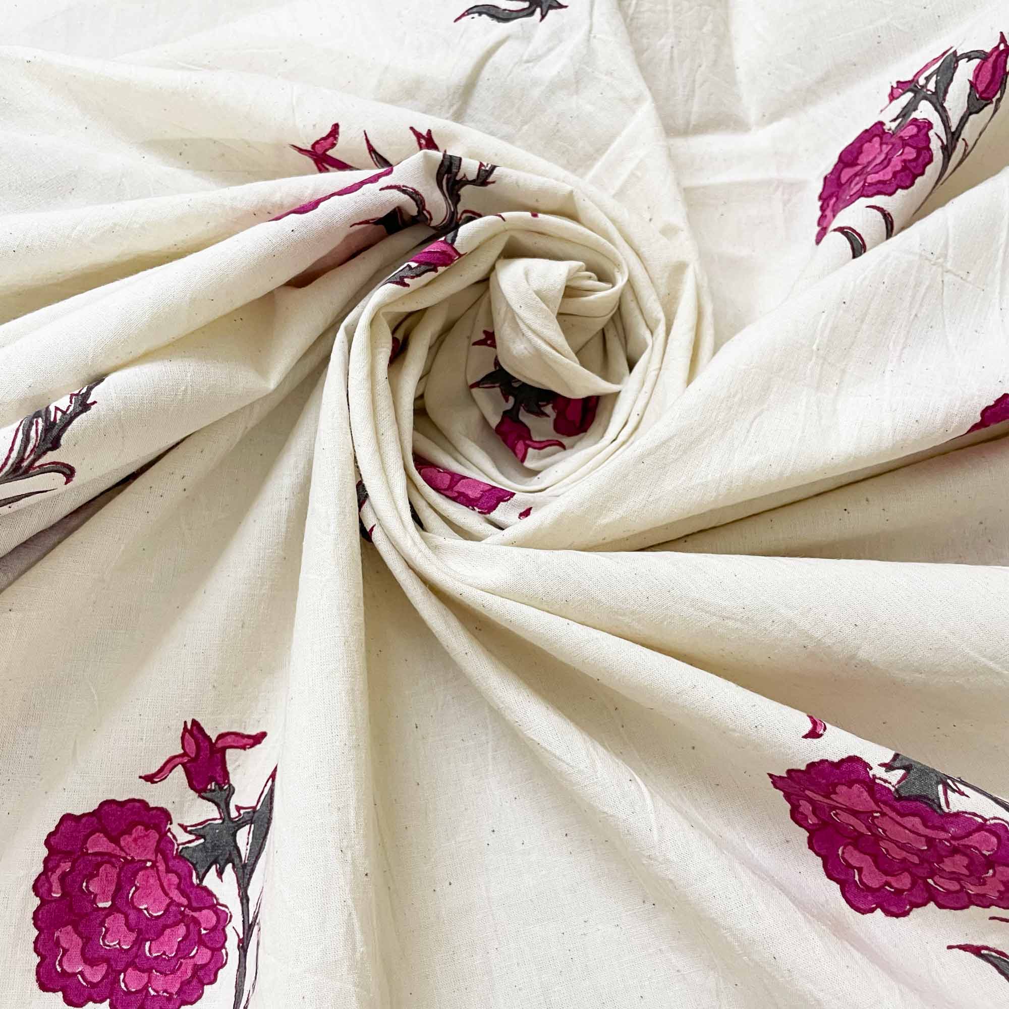 Rolled-up fabric with pink floral patterns on a white background