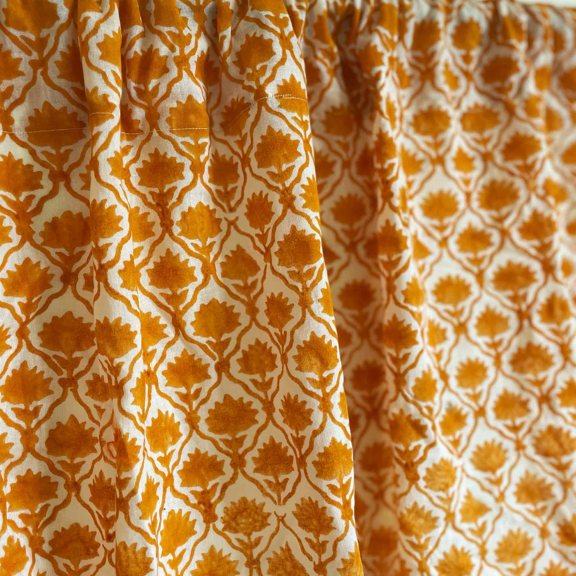 Patterned fabric with orange and white design on a light background