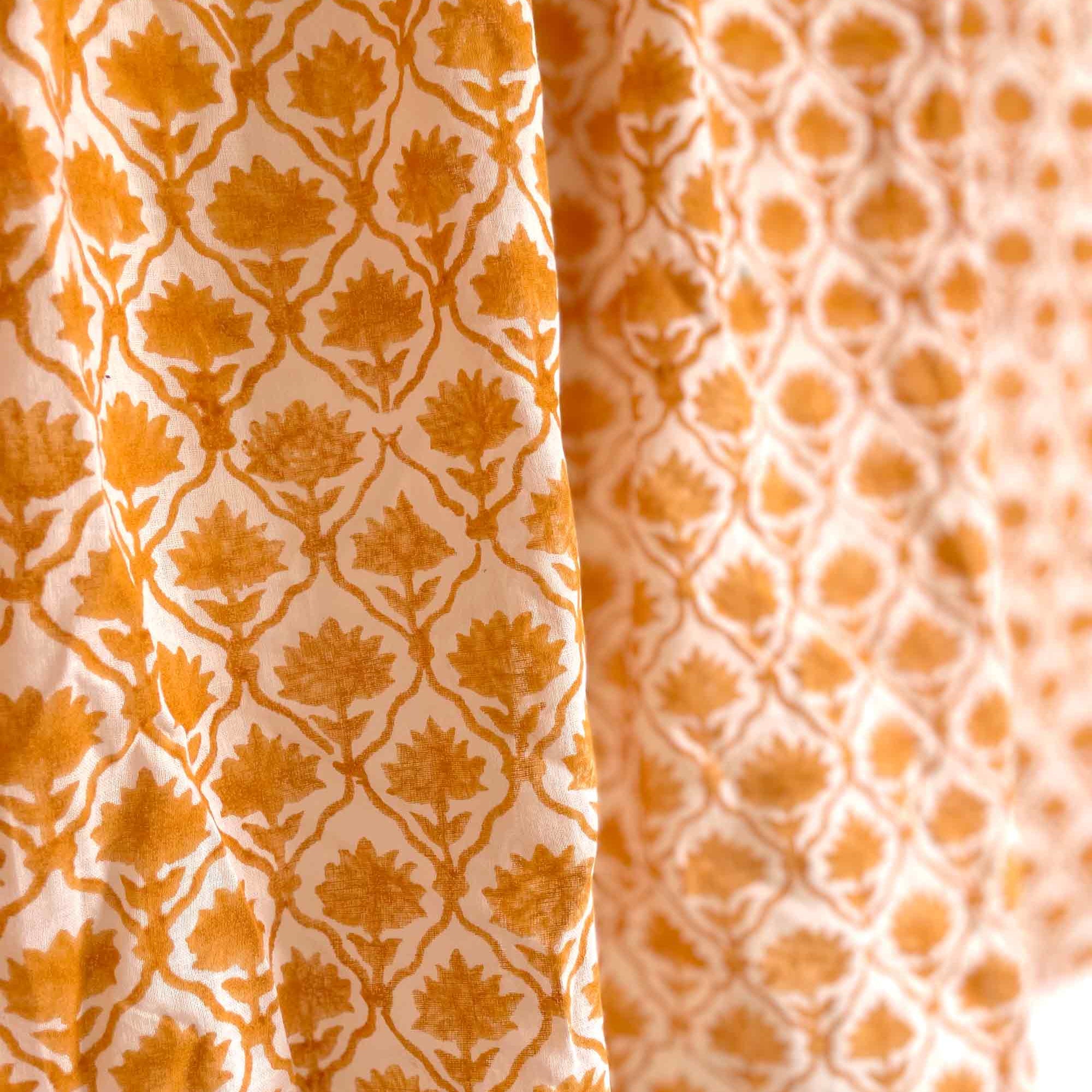 Close-up of two different patterns of orange fabric on a white background