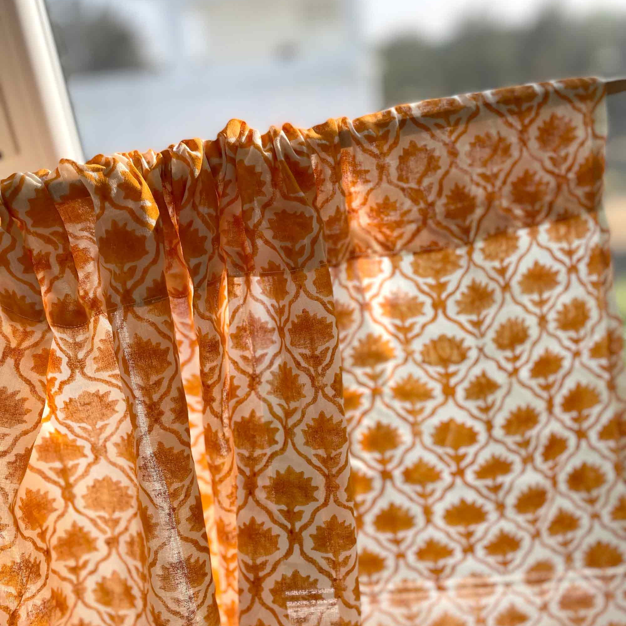 Orange and white patterned fabric draped over a surface with a blurred outdoor background.