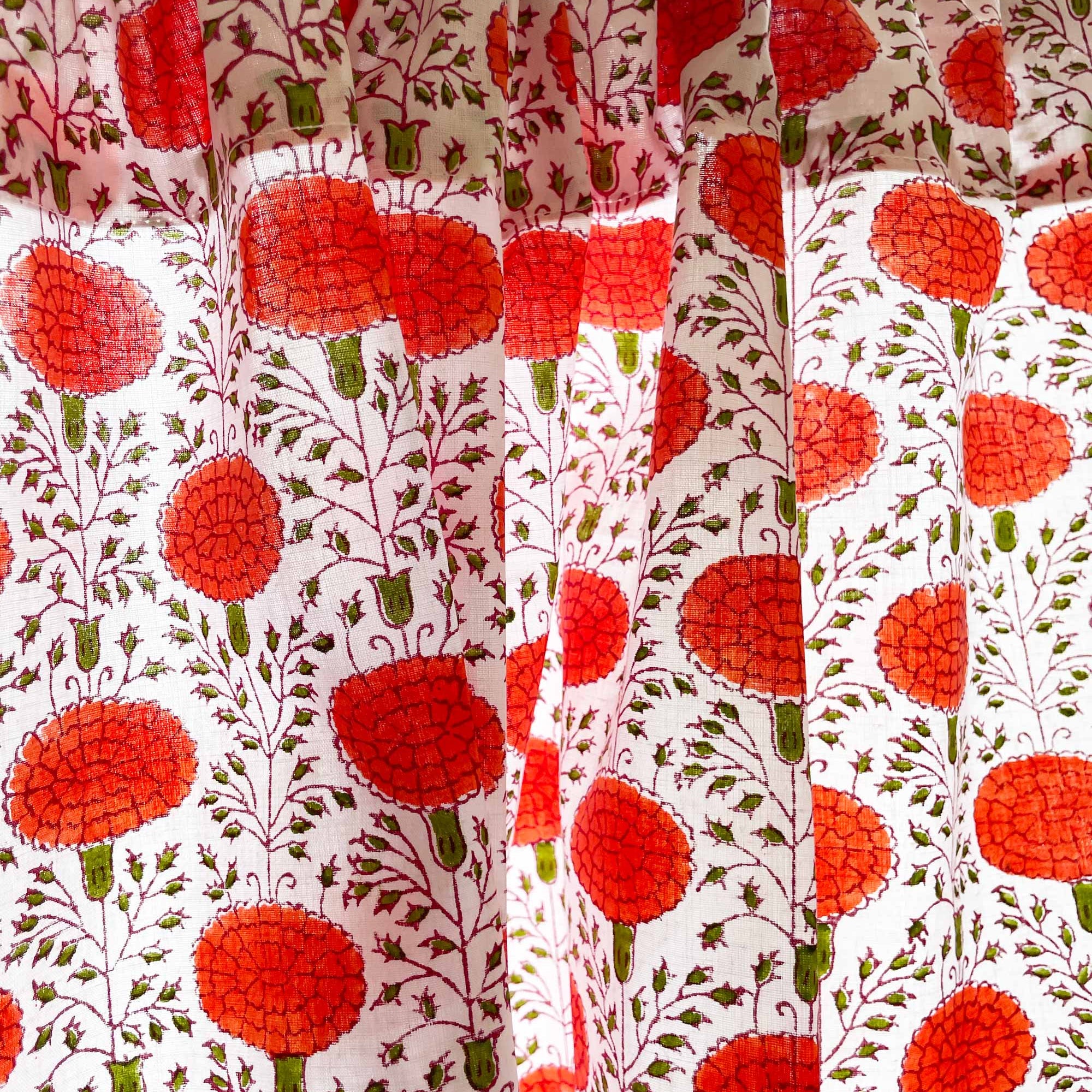 Close-up of a fabric with red floral pattern on a white background