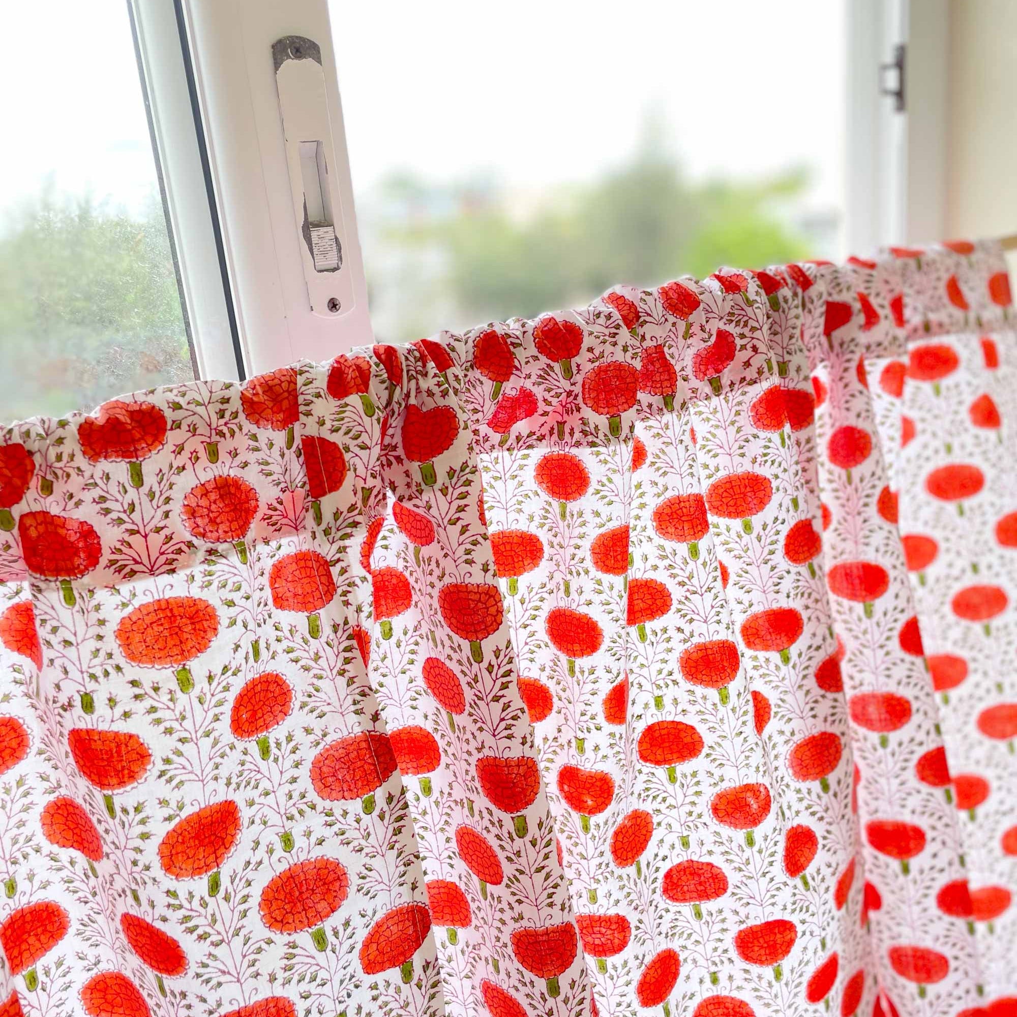 Window with a curtain featuring red floral pattern