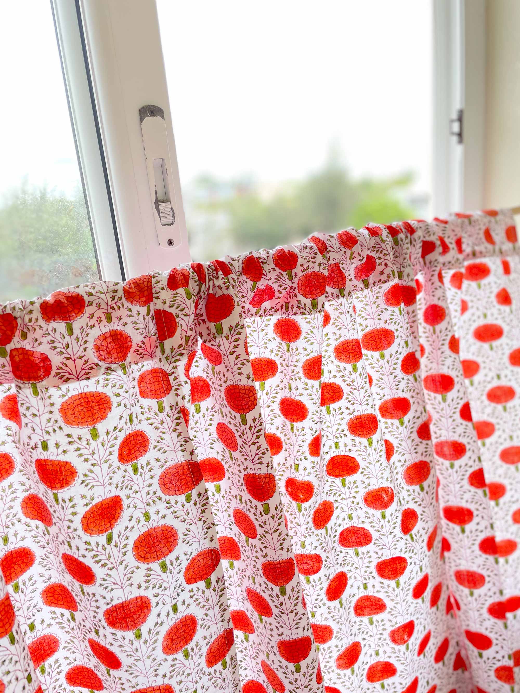 Window with a curtain featuring red floral pattern