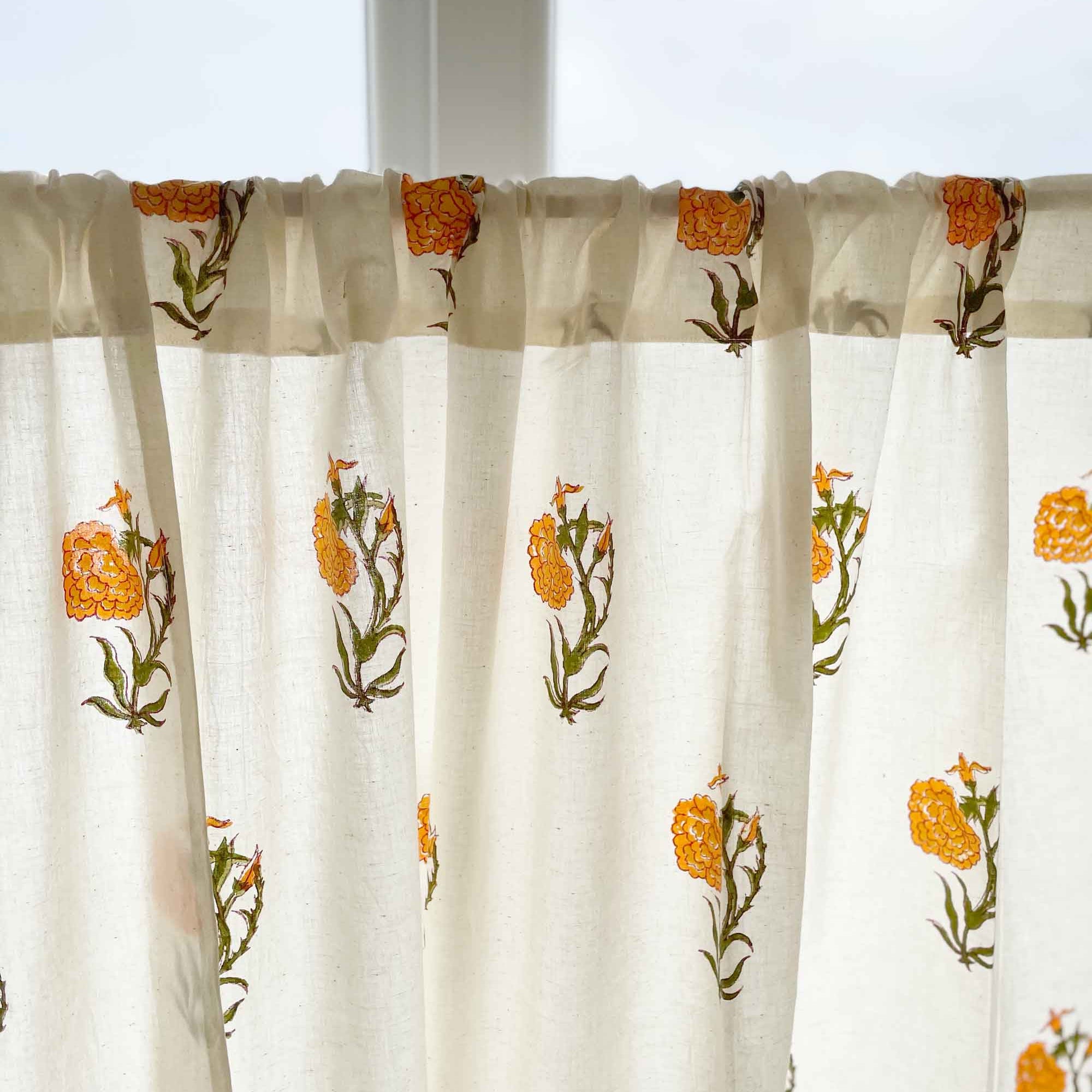 Floral marigold print cotton café curtain with green leaves, perfect for cupboards and sink skirts.