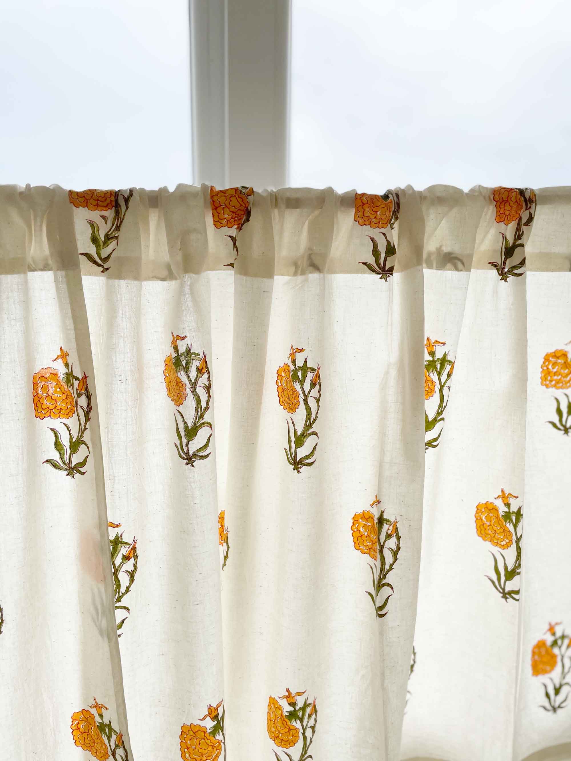 Floral marigold print cotton café curtain with green leaves, perfect for cupboards and sink skirts.