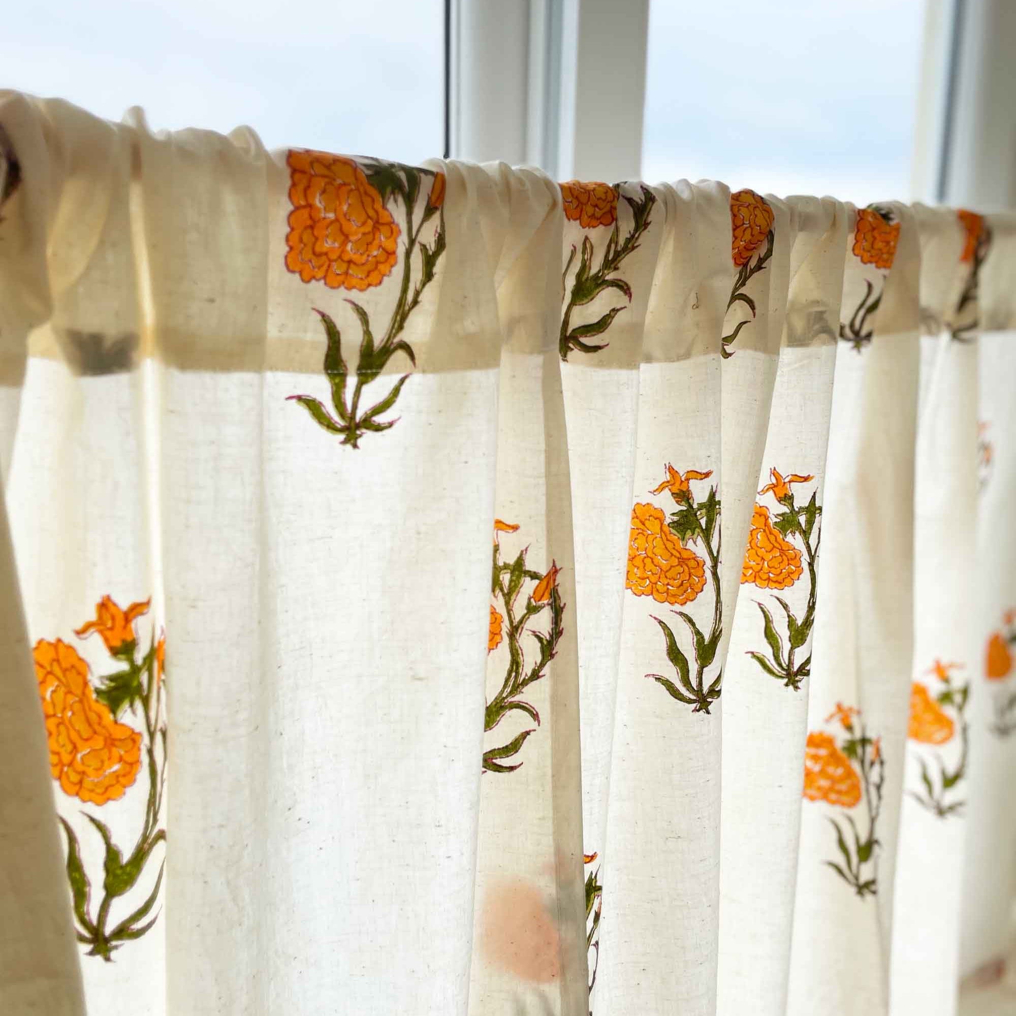 Rod pocket café curtain with orange marigold flowers and beige base, ideal for hiding storage spaces.