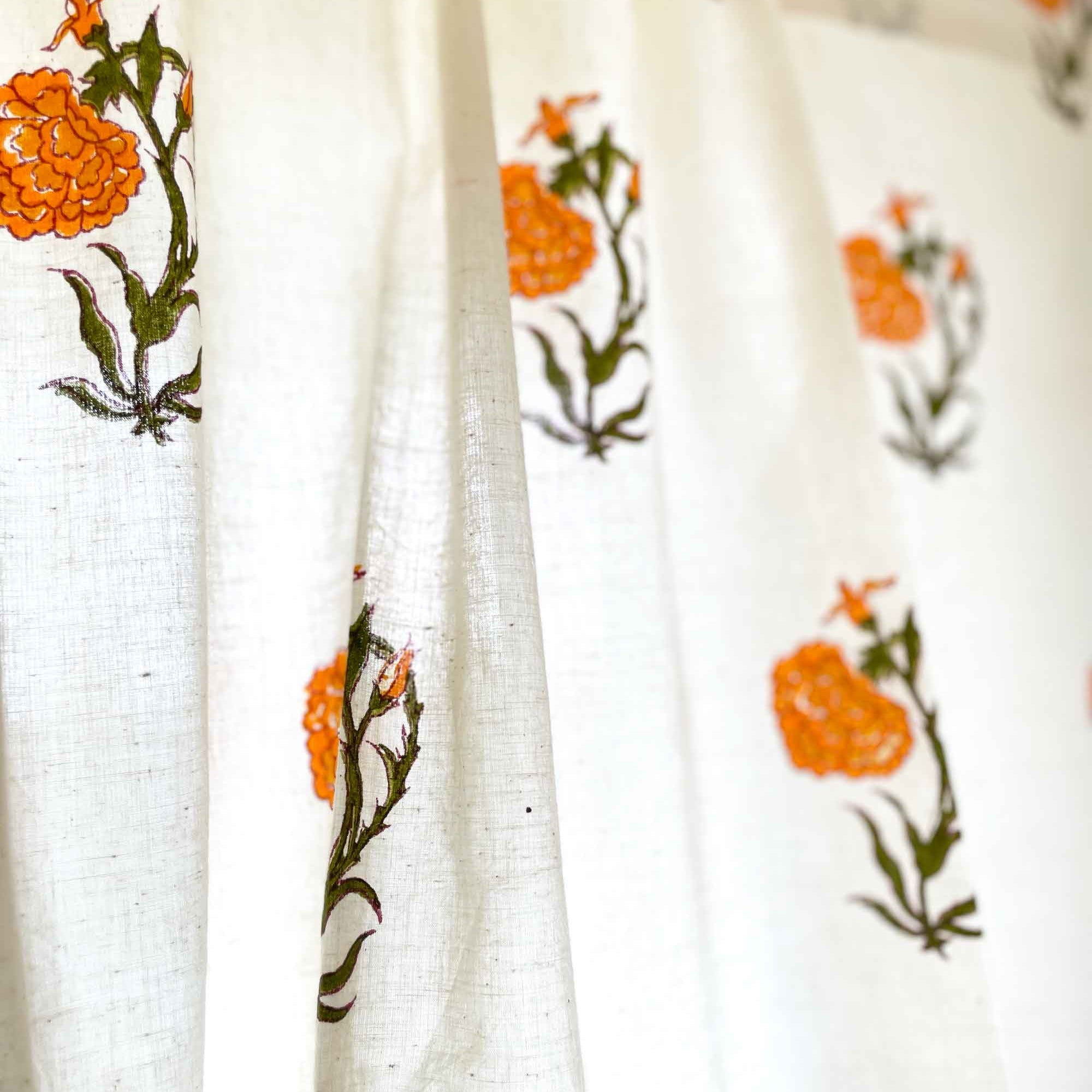 Orange marigold floral café curtain with green leaves, versatile for kitchen cupboards and sink skirts.