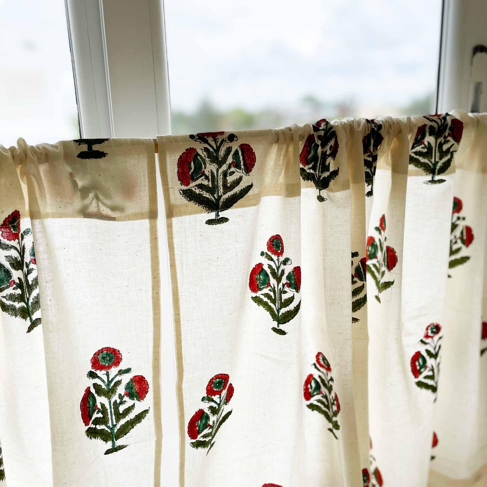 Rust and green poppy flower café curtain on white cotton background, Mughal-inspired design.