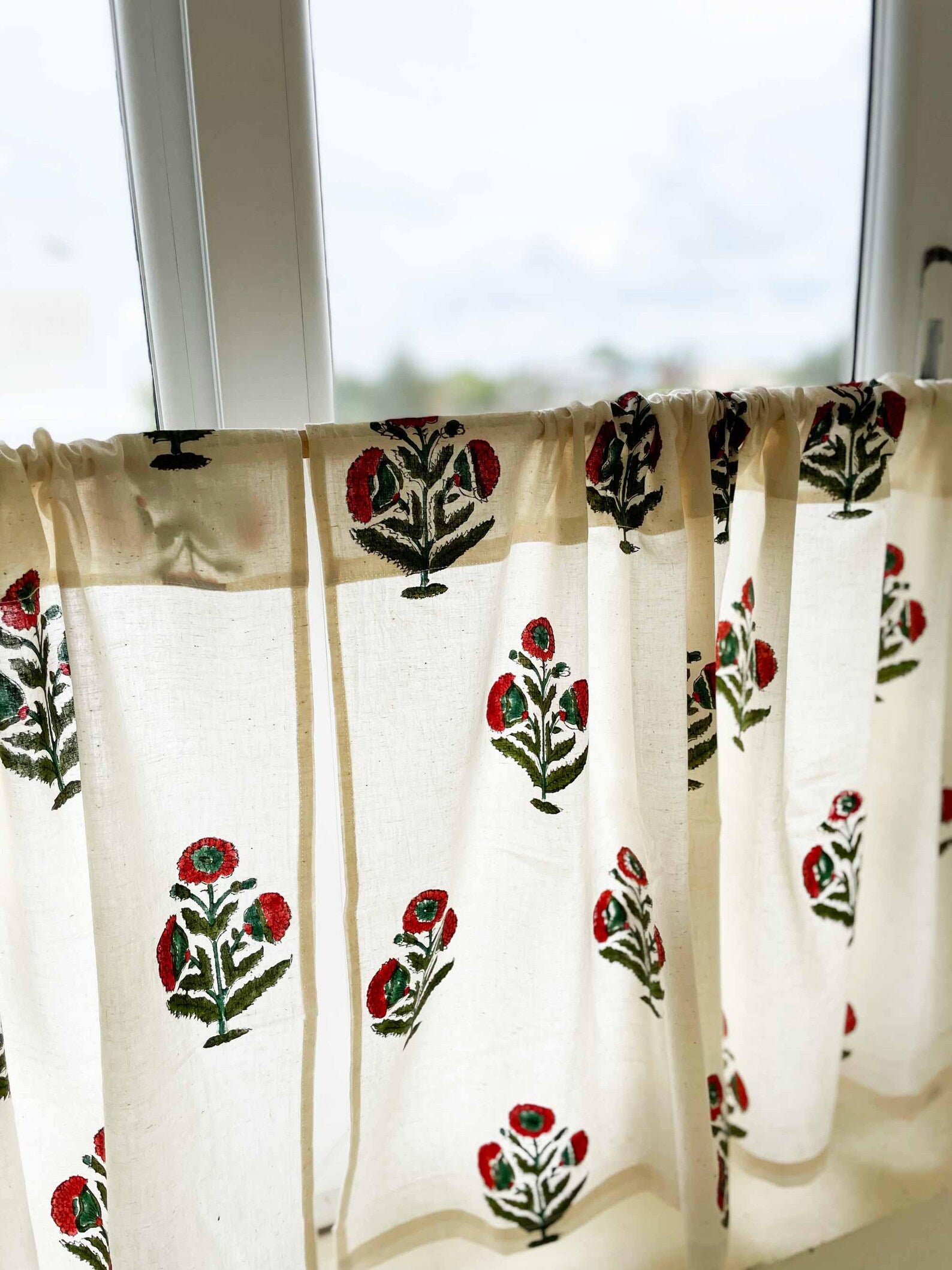 Rust and green poppy flower café curtain on white cotton background, Mughal-inspired design.