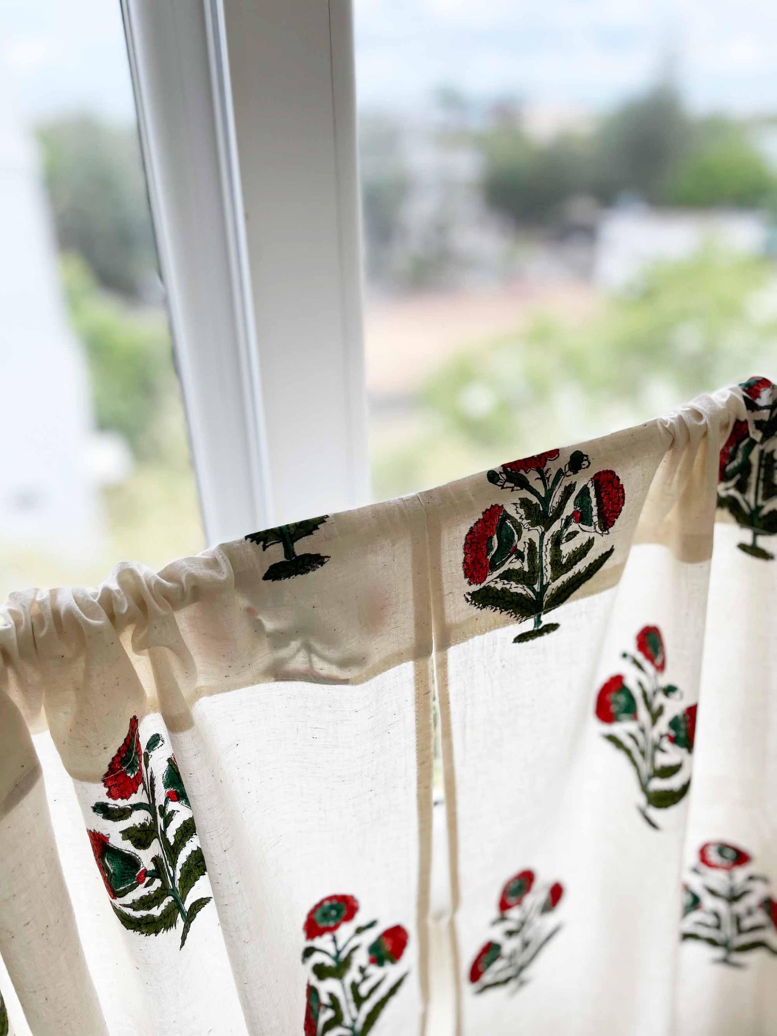 Cotton sink skirt curtain with rust and green poppy flower print, ideal for hiding storage.