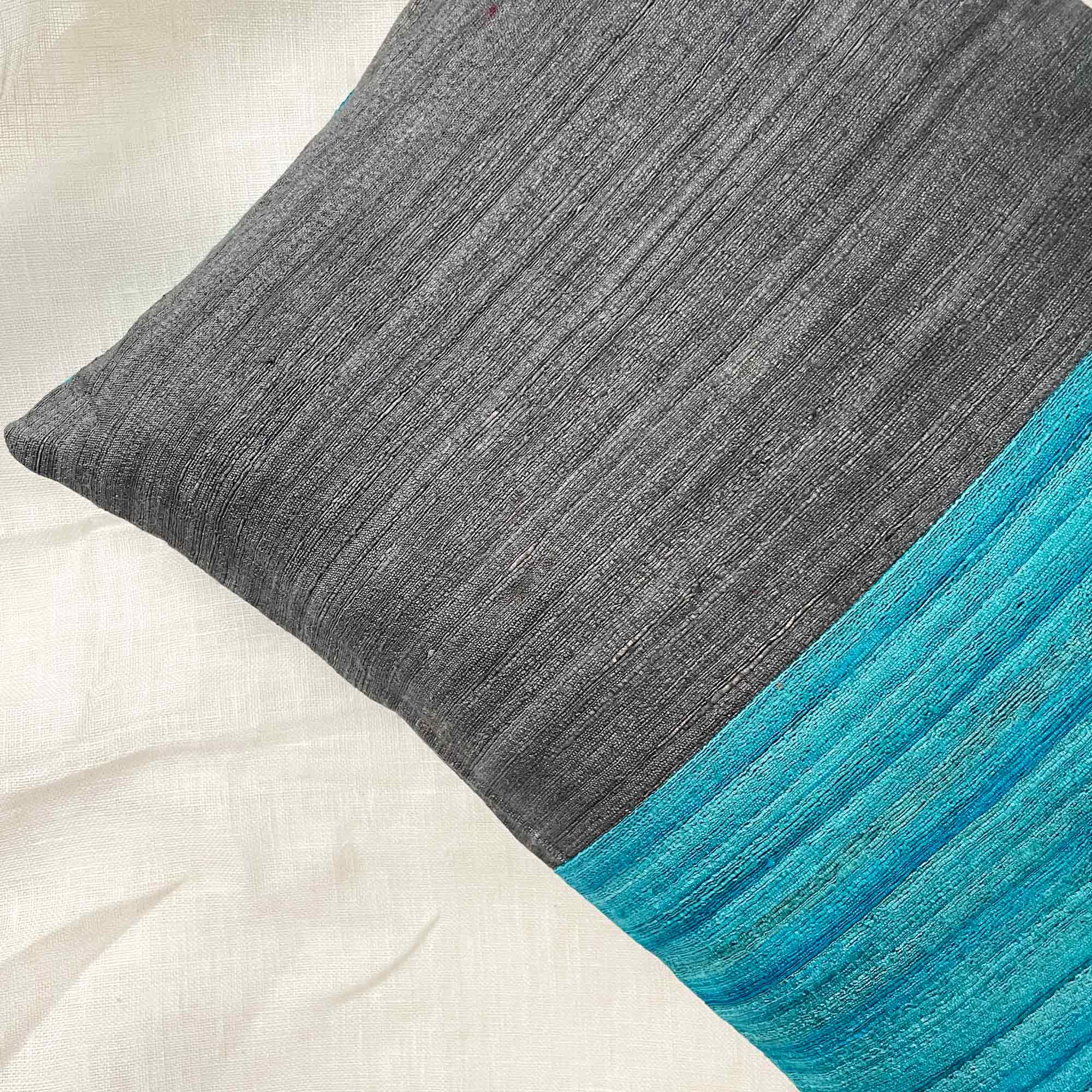 Grey and teal colorblock silk pillow cover featuring bold striped design and artisanal woven texture.