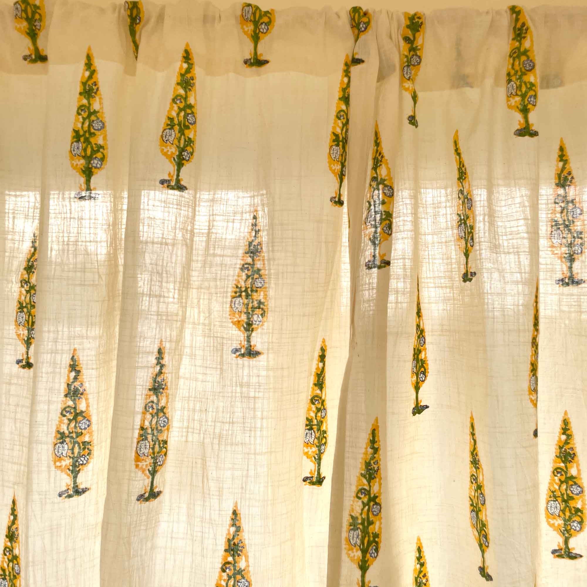 Sheer curtain with floral patterns in green and yellow on a beige background