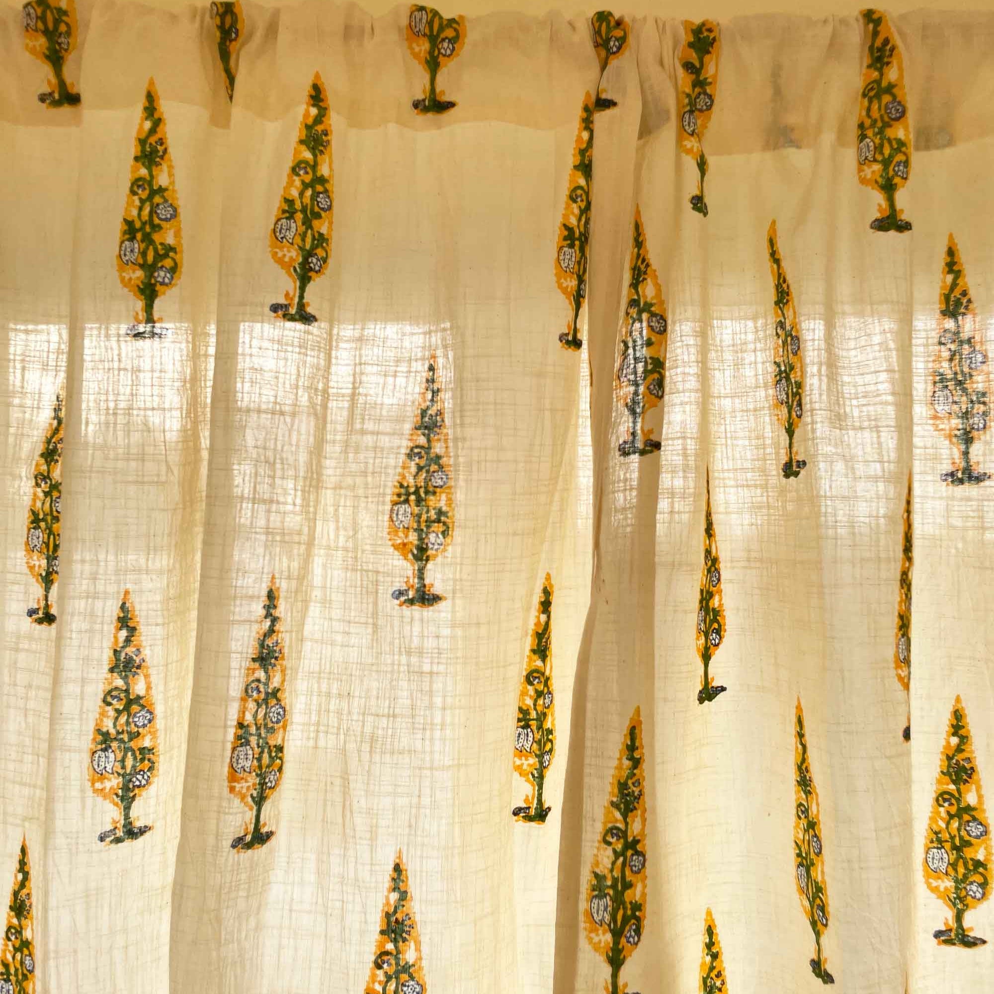 Sheer curtain with decorative yellow patterns on a white background
