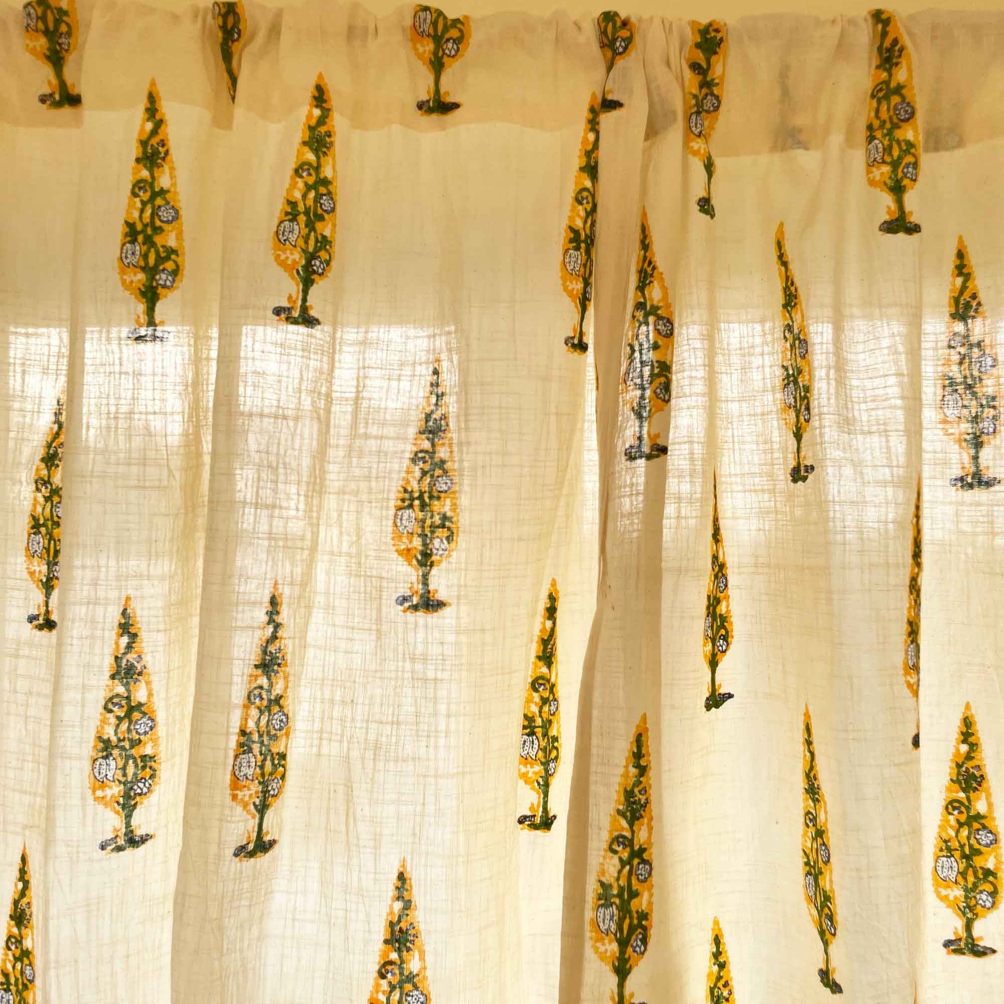 Sheer curtain with decorative yellow patterns on a beige background