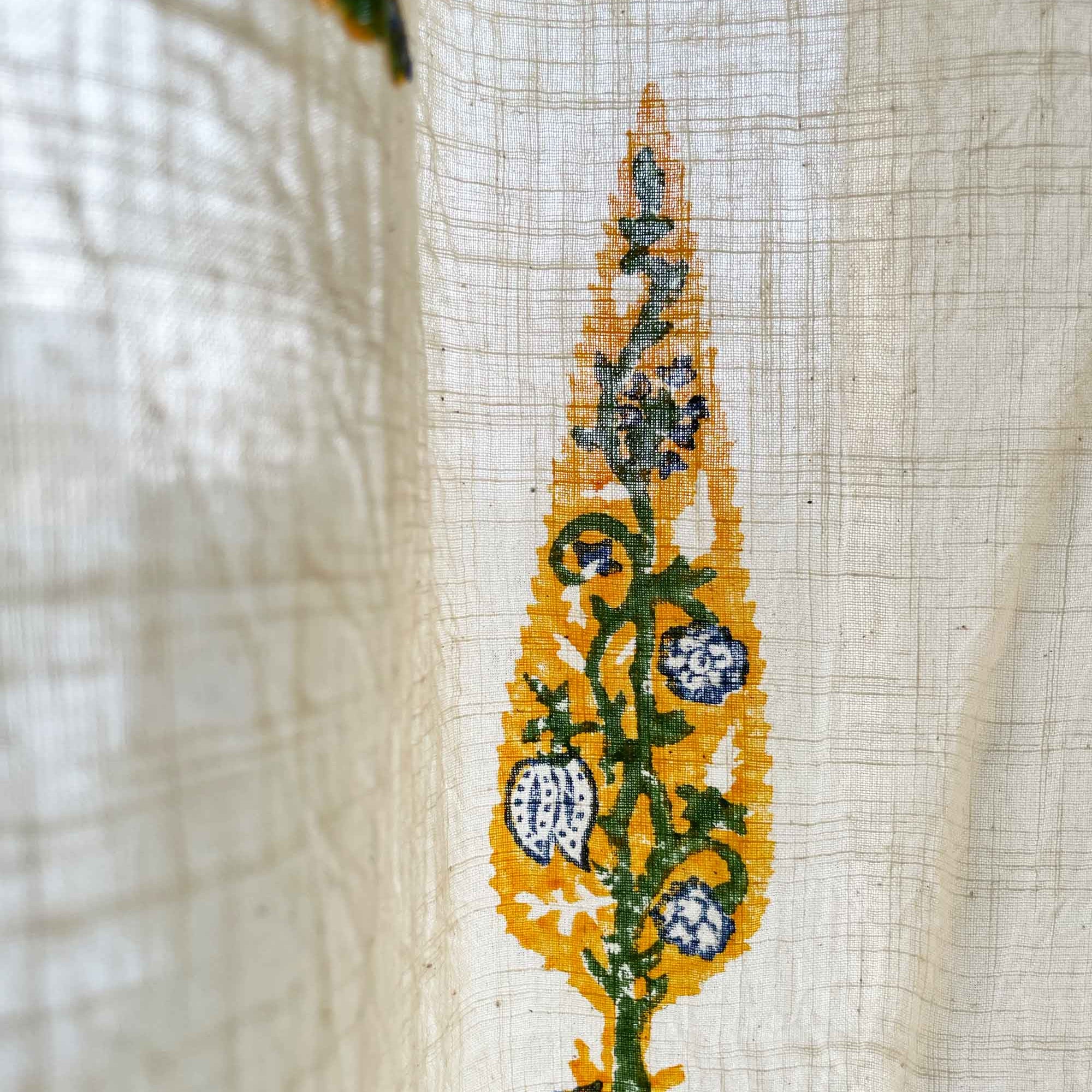 Embroidered design on fabric with yellow, green, and blue colors.