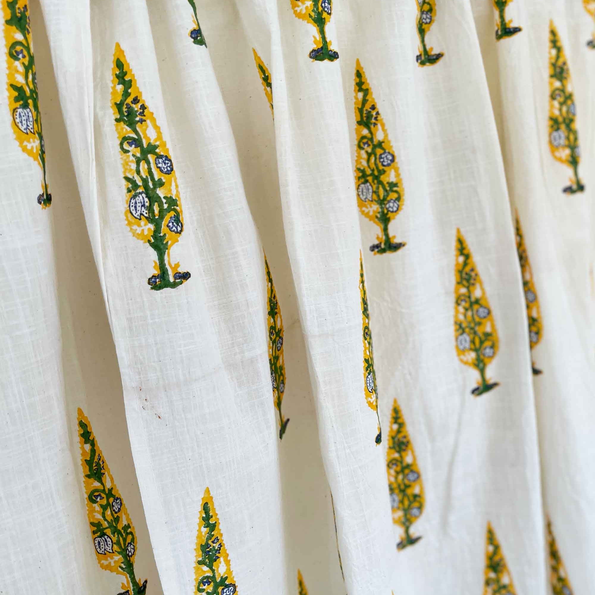 Close-up of white fabric with yellow and green floral patterns