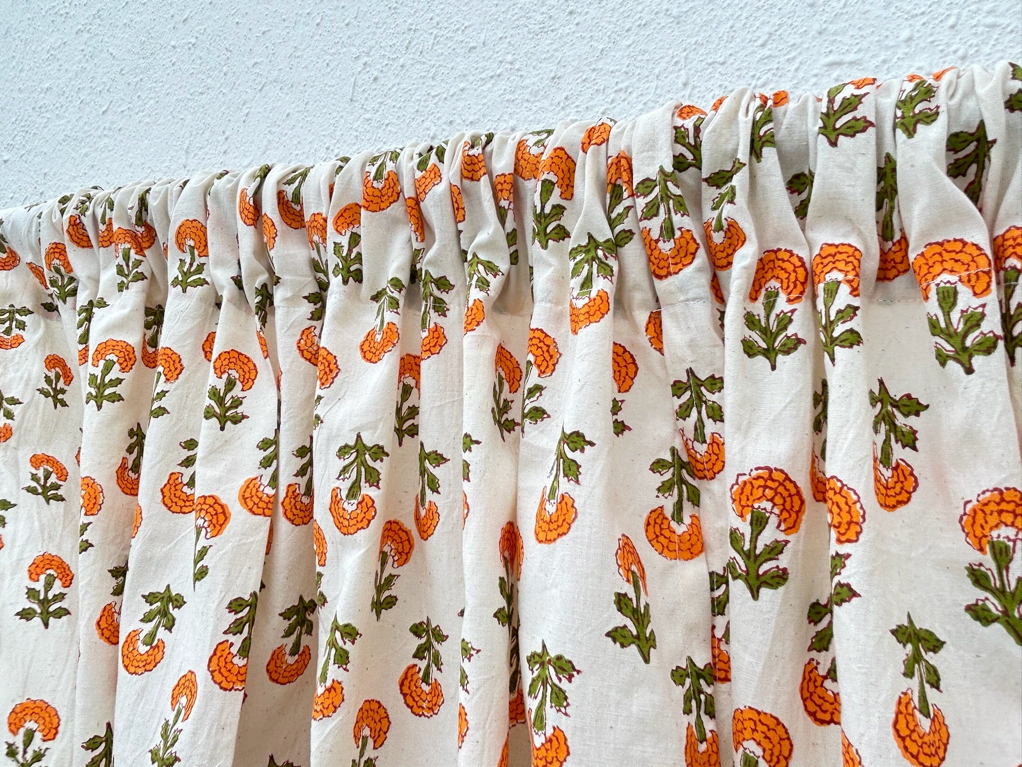 Floral patterned fabric with orange and green flowers on a white background