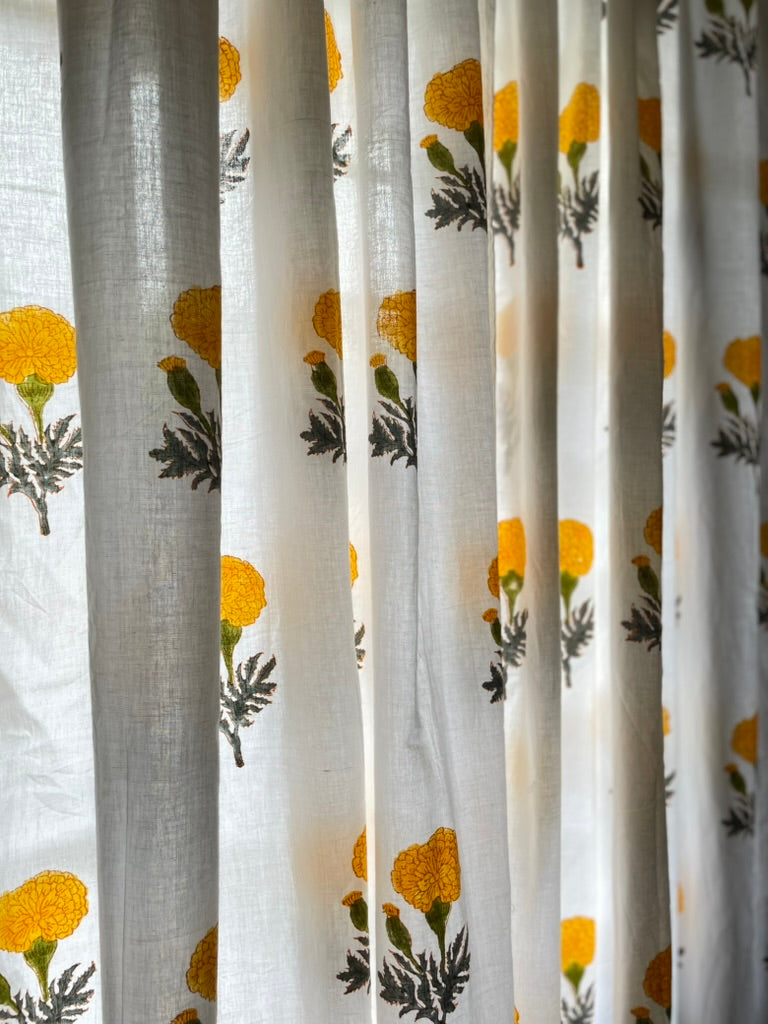 Sheer curtain with yellow floral pattern on a white background