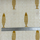 Fabric with gold fish pattern and wavy lines, measured by a ruler.