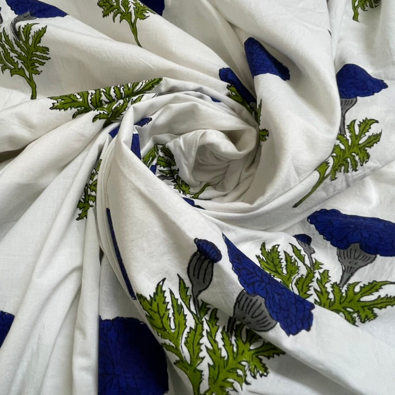 White fabric with a blue and green botanical block print pattern, styled in a spiral drape.