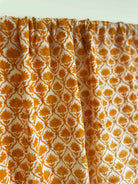 Patterned fabric with orange and white design on a light background