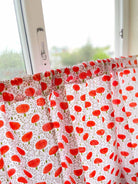 Window with a curtain featuring red floral pattern