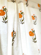 Orange marigold floral café curtain with green leaves, versatile for kitchen cupboards and sink skirts.