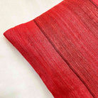 Styled red striped tussar silk pillow cover emphasizing handcrafted weave, subtle sheen, and heritage fabric appeal.